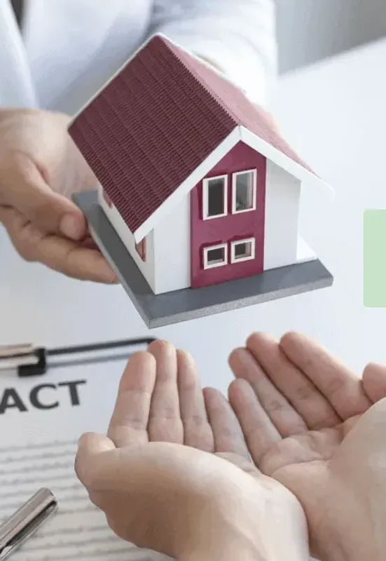 A model house held in open hands over a contract